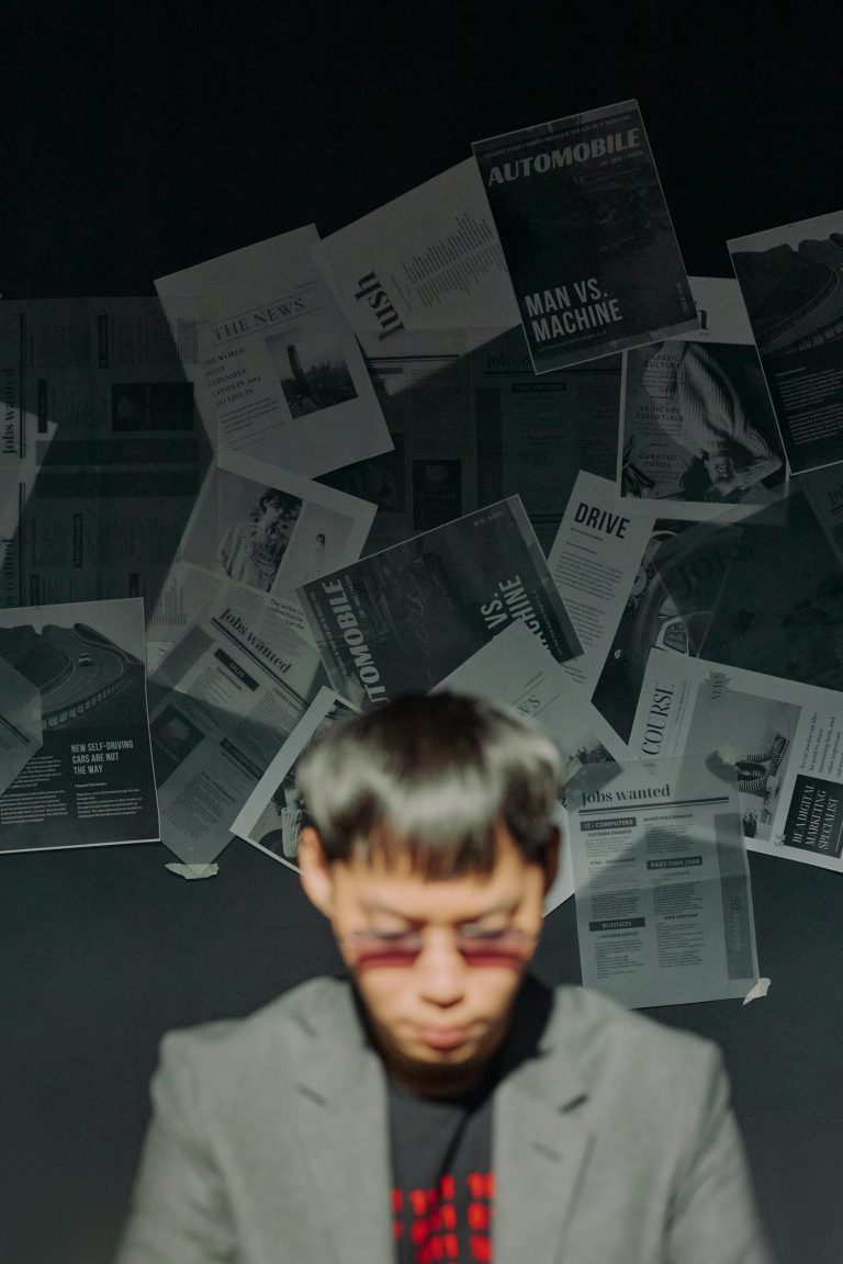 Man Sitting on the Background of Papers Stuck to the Wall 