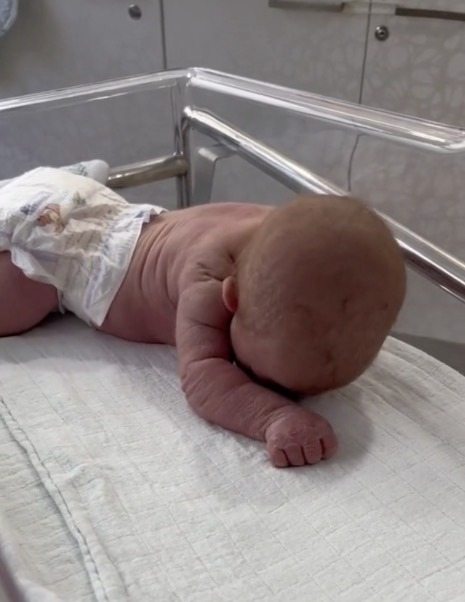 Newborn baby crawls across the hospital cot